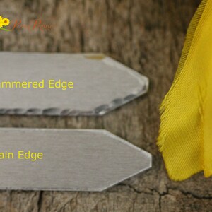 May include: Two gray slate signs with arrow shapes. The top sign has a hammered edge and the text "Hammered Edge". The bottom sign has a plain edge and the text "Plain Edge".