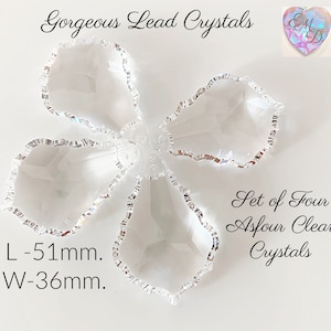 May include: A set of four clear Asfour crystals, arranged in a flower-like pattern. Each crystal has a unique, irregular shape with a shimmering, silver-colored edge. The crystals are 51mm long and 36mm wide. Text reads "Gorgeous Lead Crystals".