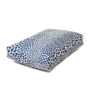 May include: A rectangular blue and white patterned dog bed. The bed is made of a soft, durable fabric and has a comfortable, supportive filling.