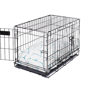 May include: A black metal dog crate with a white and blue patterned bed inside. The crate has a door on the side that is open.