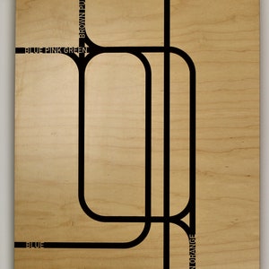 May include: A wooden wall art piece with a light brown finish. Black lines form a stylized map of Chicago, with text indicating color-coded routes. The word "CHICAGO" is printed in black at the bottom.