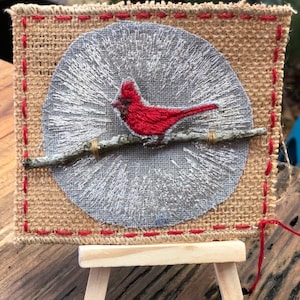 Redbird Cardinal Weihnachtsverzierung mit Handstich, Band, Zweig & Sackleinen zum Aufhängen oder für den Tisch. Mit Staffelei.