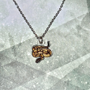 May include: A white ceramic mug with a black handle and the text "But First, Coffee" in a bold, black font. The mug is set against a neutral background, highlighting its simple design.