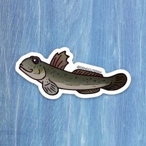 May include: A sticker featuring a cartoon illustration of a fish with a light green body, dark green spots, and a dark brown fin. The sticker has a white border and the text "@dangcutefish".