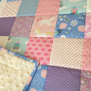 May include: A patchwork quilt with a variety of colorful patterns, including stars, flowers, crowns, and unicorns. The quilt is made of soft, comfortable fabric and is perfect for a child's room.