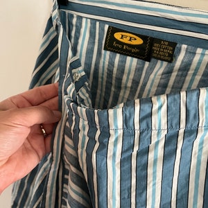 May include: Blue and white striped cotton skirt with a Free People label. The label says "100% cotton made in Nepal RN 66170 care on reverse."
