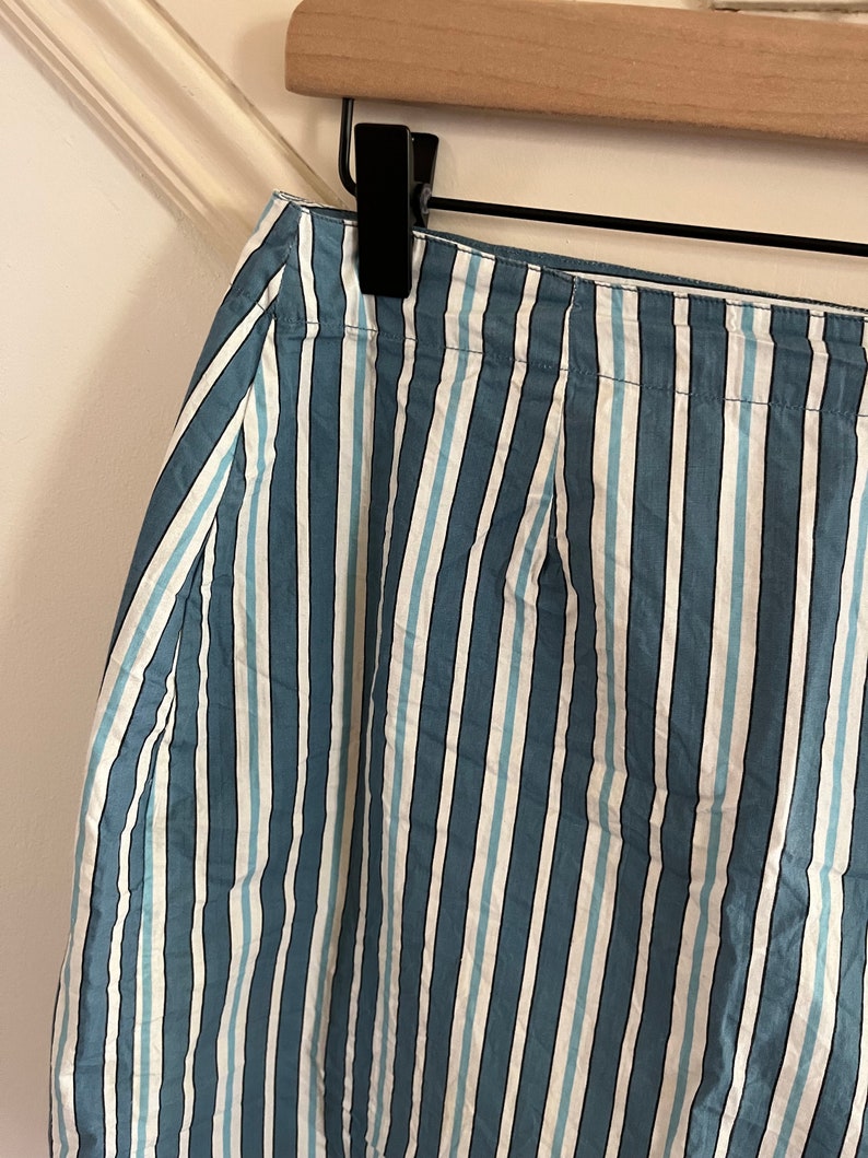 May include: A blue and white striped skirt with a wide waistband.