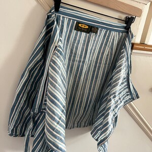 May include: A blue and white striped button-down shirt with a label that reads "FP Lee People".