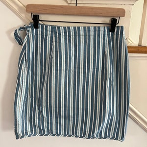 May include: A blue and white striped skirt with a tie at the waist.