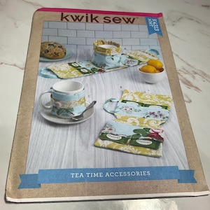May include: A sewing pattern for tea time accessories. The pattern includes instructions for making a tea cozy, a tea bag holder, and a mug cozy. The pattern is called "Kwik Sew" and the pattern number is K4313.