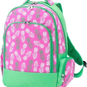 May include: A pink and green backpack with a pineapple print. The backpack has a large main compartment, a smaller front pocket, and a side pocket. The backpack has a padded back and adjustable straps.