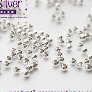 May include: A scattering of silver-toned round beads, ideal for jewellery making. The beads are small and have a smooth, shiny finish.