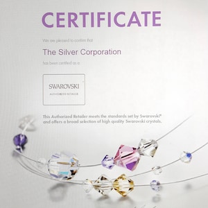 May include: A certificate confirming that The Silver Corporation is an authorized retailer of Swarovski crystals. The certificate is dated May 28, 2015 and expires December 31, 2016. The certificate features a Swarovski logo and a string of colorful crystals.