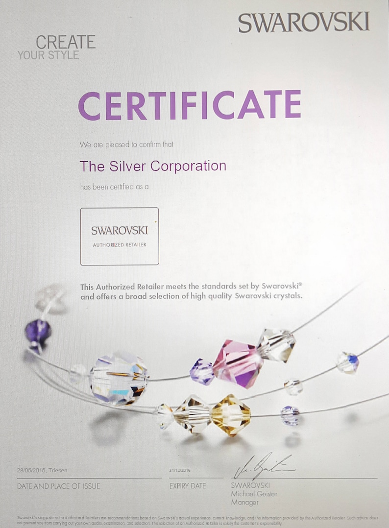 May include: A certificate confirming that The Silver Corporation is an authorized retailer of Swarovski crystals. The certificate is dated May 28, 2015 and expires December 31, 2016. The certificate features a Swarovski logo and a string of colorful crystals.