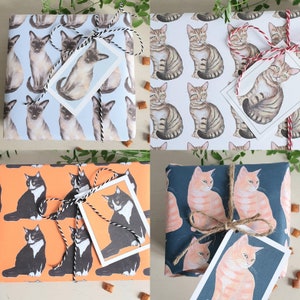 May include: Four gift-wrapped boxes with different cat-themed wrapping paper. Each box has a different color scheme and pattern. The boxes are tied with twine and have gift tags attached.