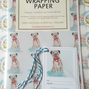 May include: A set of wrapping paper featuring a dog illustration, with two A3 (29.7x42cm) sheets and two gift tags. The design includes a dog holding a red leash. Hand produced in Norfolk, England.