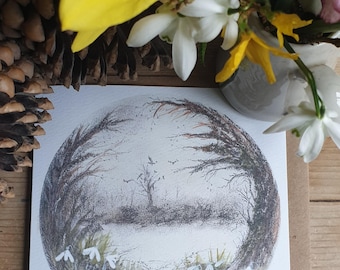 May include: A white card with a circular illustration of a snow-covered forest scene with white snowdrops in the foreground. The card is surrounded by yellow and white flowers.
