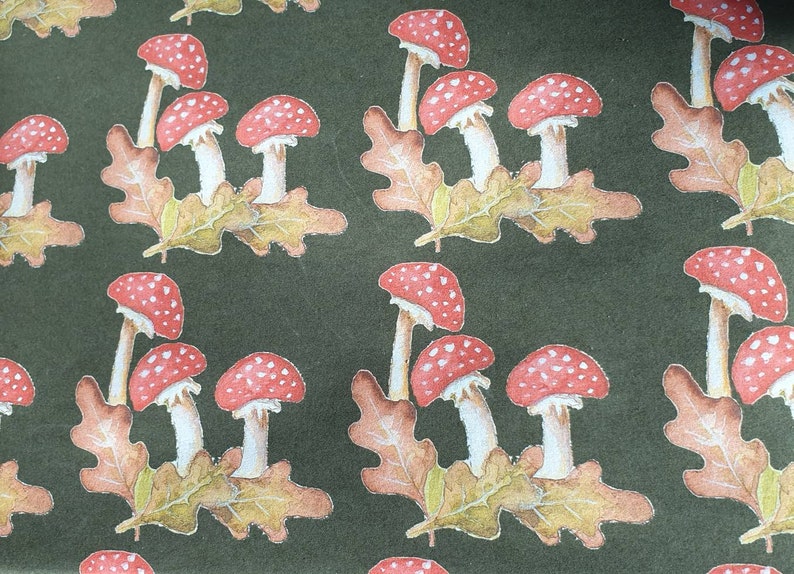 K&ouml;nnte beinhalten: Ein sich wiederholendes Muster aus roten und wei&szlig;en Pilzen mit wei&szlig;en Stielen auf dunkelgr&uuml;nem Hintergrund. Die Pilze sind in Gruppen von drei angeordnet und von braunen und gr&uuml;nen Bl&auml;ttern umgeben.