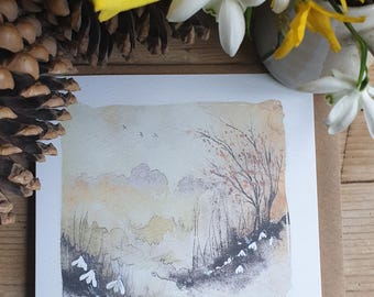 May include: A watercolor painting of a winter landscape with snowdrops in the foreground and a tree with bare branches in the background. The sky is a soft yellow and the ground is covered in a light dusting of snow.