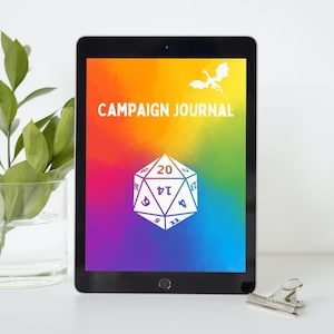 Può includere: Un tablet nero con uno sfondo colorato che mostra un dado a 20 facce con i colori dell'arcobaleno e un drago bianco. Il testo "Campaign Journal" è visualizzato sullo schermo.