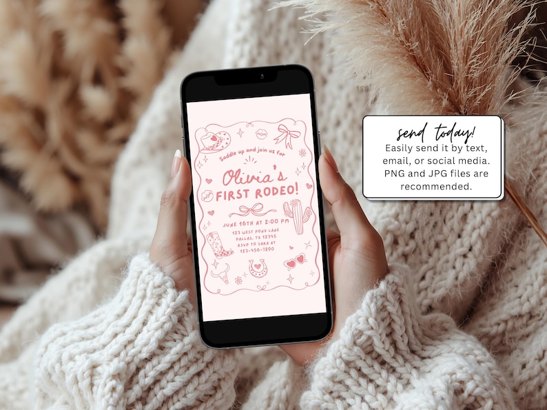 May include: A smartphone displays a pink invitation for "Olivia's First Rodeo!" with cowboy-themed illustrations. The phone is held by a person wearing a cream-colored sweater. A small white sign reads "send today!"