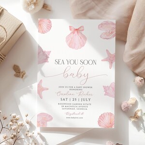 Puede incluir: Una tarjeta de invitación para baby shower blanca con ilustraciones en acuarela de conchas marinas rosas, estrellas de mar y una perla en una concha. El texto dice: SEA YOU SOON baby, JOIN US FOR A BABY SHOWER HONORING Caroline Richer, SAT | 25 | JULY, ROSEWOOD GARDEN ESTATE, 28 MAGNOLIA AVENUE, SAVANNAH, GEORGIA, Registered at www.babylist.com.