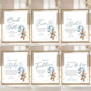 May include: Set of six framed signs with gold borders. Each sign features a watercolor teddy bear holding blue balloons. Text on the signs includes "Cards + Gifts," "Take a Favor," "Guest Book," "Don't Say Baby," "Family Traditions," and "Message From the Bump."