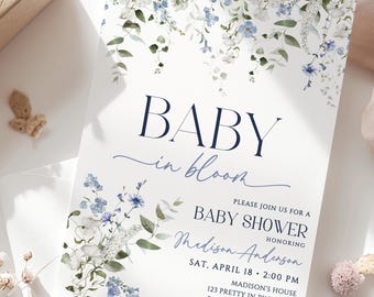 May include: A baby shower invitation with a floral design. The invitation features the words "BABY in bloom" in navy blue script. The invitation also includes the date, time, and location of the baby shower.