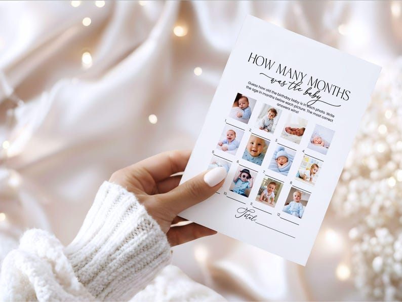 Pode incluir: Um cart&atilde;o branco com o texto "HOW MANY MONTHS was the baby" e uma grade de fotos de beb&ecirc;s. O cart&atilde;o &eacute; segurado por uma pessoa vestindo um su&eacute;ter branco. O cart&atilde;o &eacute; para um jogo de ch&aacute; de beb&ecirc;.