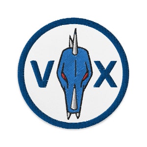 May include: A blue and white embroidered patch with a blue dragon head and the word "VOX" in blue lettering.