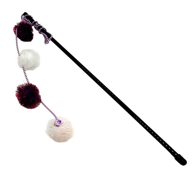 May include: A black wand with a purple and white pom-pom attached to the end. The wand is about 24 inches long and has a black tip. The pom-pom is made of soft, fluffy material.