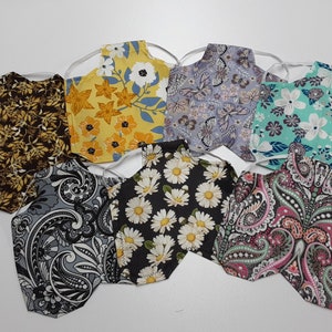 May include: Eight fabric face masks with different floral and paisley patterns. The masks are all made of cotton and have adjustable ear loops.