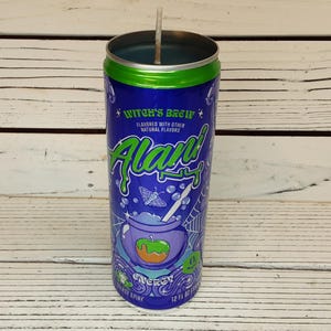 May include: A blue and green candle in a can, labeled "Witch's Brew". The can features a cauldron graphic with a green apple and orange accents, along with the text "Alan". The candle is 12 fl oz.