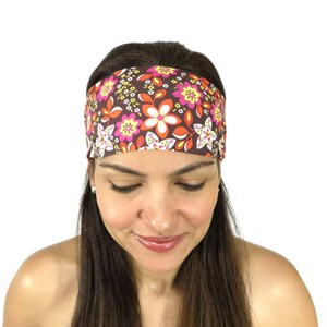Puede incluir: Una diadema marrón con un estampado floral en tonos de rosa, naranja, amarillo y blanco. La diadema está hecha de un tejido suave y elástico, ideal para mantener el cabello fuera de la cara.