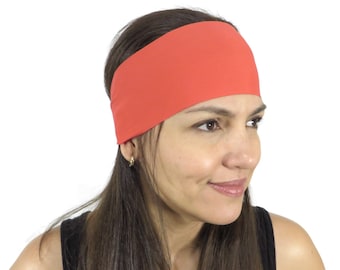 Könnte beinhalten: Ein korallenfarbenes Stirnband aus weichem Stoff. Das Stirnband wird von einer Person mit langen braunen Haaren getragen.