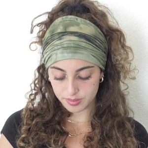 Puede incluir: Una diadema ancha verde oliva con dise&ntilde;o tie-dye. La tela est&aacute; fruncida y envuelta alrededor de la cabeza. La diadema est&aacute; hecha de un material suave y est&aacute; dise&ntilde;ada para mantener el cabello fuera de la cara. El dise&ntilde;o tie-dye presenta tonos verdes y negros.