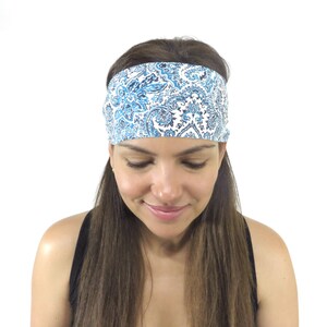 May include: A woman with long brown hair is wearing a blue and white patterned headband. The headband is made of fabric and has a paisley design.