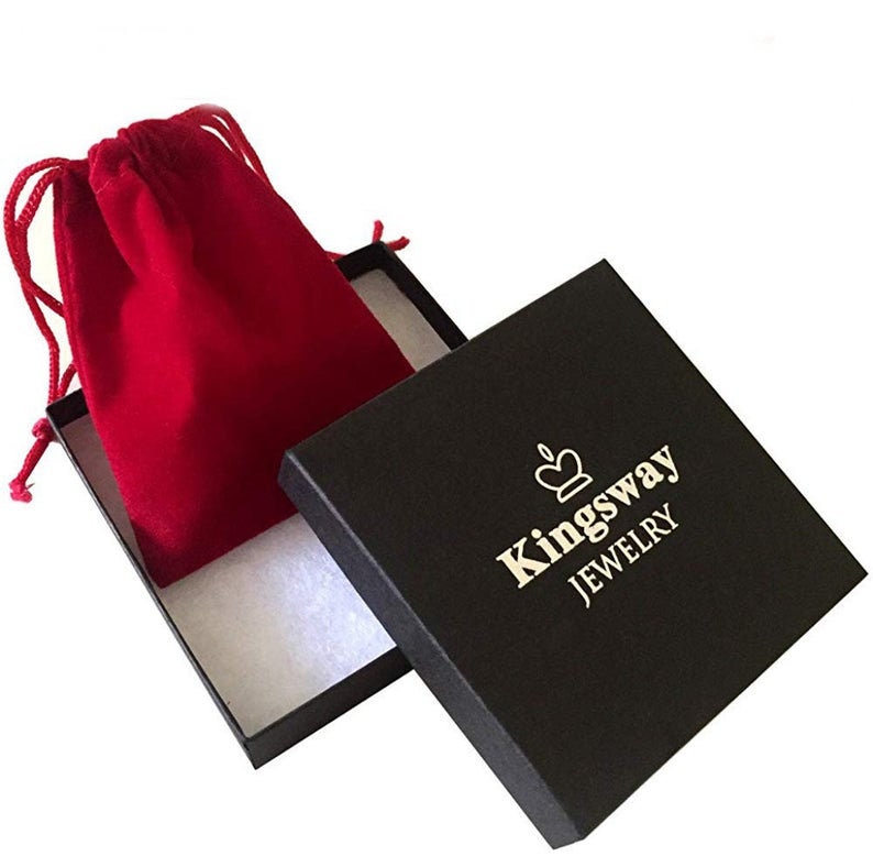 Peut inclure: Une bo&icirc;te &agrave; bijoux carr&eacute;e noire avec un int&eacute;rieur blanc et un logo couronne dor&eacute; au-dessus du texte Kingsway JEWELRY. Une pochette &agrave; cordon en velours rouge est plac&eacute;e dans la bo&icirc;te ouverte, avec des cordons rouges assortis et une texture douce.