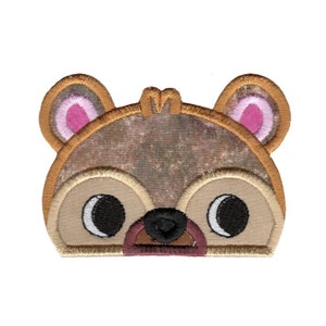 May include: Embroidered iron-on patch featuring a cartoon bear face with brown fur, pink ears, and black eyes.