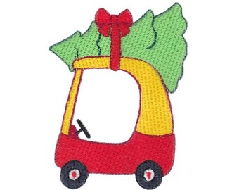 以下が含まれることがあります： 赤い車と黄色の車のおもちゃが、緑のクリスマスツリーと赤いリボンを運んでいる刺繍パッチ。パッチには黒い車輪と黒いハンドルがあり、クリスマスのクラフトやアパレルに最適です。