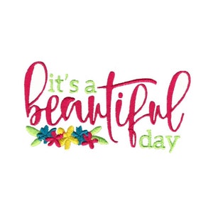 Peut inclure: Broderie "C'est un beau jour" avec une inscription rose et une guirlande florale de fleurs jaunes, rouges, bleues et vertes.