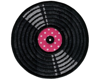 May include: A black vinyl record with a pink polka dot center. The record is made of fabric and has a textured surface.