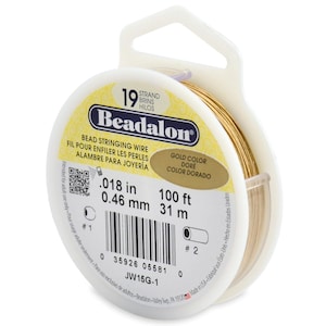 May include: A spool of gold-colored Beadalon bead stringing wire. The label indicates 19 strands, a diameter of .018 inches, and a length of 100 feet. The spool is white plastic with a hanging tab, featuring a barcode and product code JW15G-1.
