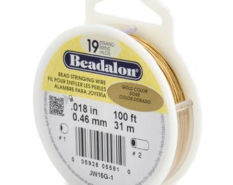 May include: A spool of gold-colored Beadalon bead stringing wire. The label indicates 19 strands, a diameter of .018 inches, and a length of 100 feet. The spool is white plastic with a hanging tab, featuring a barcode and product code JW15G-1.