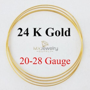 May include: A close-up of several loops of gold wire. The text on the image reads "24 K Gold" and "20-28 Gauge". The logo for M.Y. Jewelry Supply is also visible. The wire is a bright, shiny gold color.
