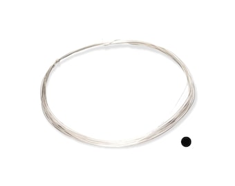 May include: A coil of thin, silver-colored wire, likely for jewelry making or crafts, is displayed against a white background. The wire is tightly wound, forming a circular shape. A small black dot is in the lower right corner.