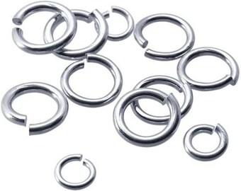 May include: A collection of silver jump rings, a type of jewelry finding, in various sizes. These rings are used for connecting jewelry components, such as chains, pendants, and charms.
