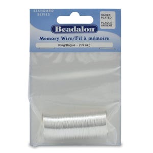 May include: A package of silver plated memory wire, also known as beadalon wire, for jewelry making. The package is labeled "Memory Wire/Fil à mémoire" and "Ring/Bague - (1/2 oz.)".