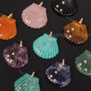 May include: A collection of nine shell-shaped pendants carved from various gemstones, including orange, pink, black, brown, purple, turquoise, green, and blue stones. Each pendant features a gold-tone metal bail and three small embedded clear crystals.