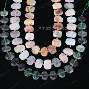 Puede incluir: Tres hileras de cuentas de piedras preciosas. La hilera superior está hecha de cuentas de ágata de color marrón claro y naranja. La hilera del medio está hecha de cuentas de aguamarina de color azul claro. La hilera inferior está hecha de cuentas de fluorita de color verde y morado.